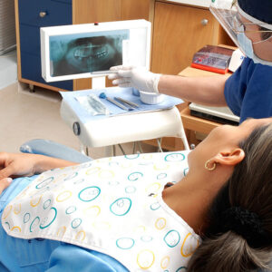 Patientin bei oralchirurgischer Untersuchung mit digitalem Röntgenbild in der Zahnarztpraxis Trier